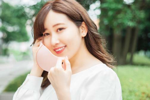 マスクを取る女性のイメージ