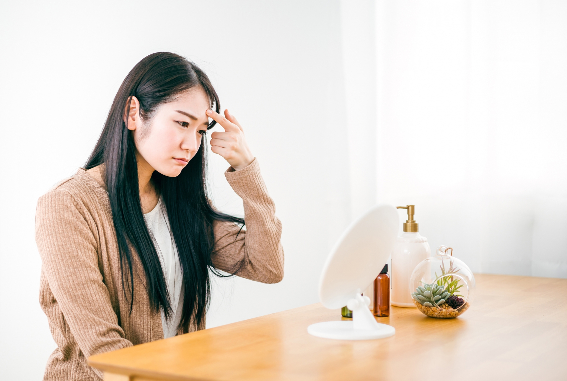 眉間にシワを寄せる女性