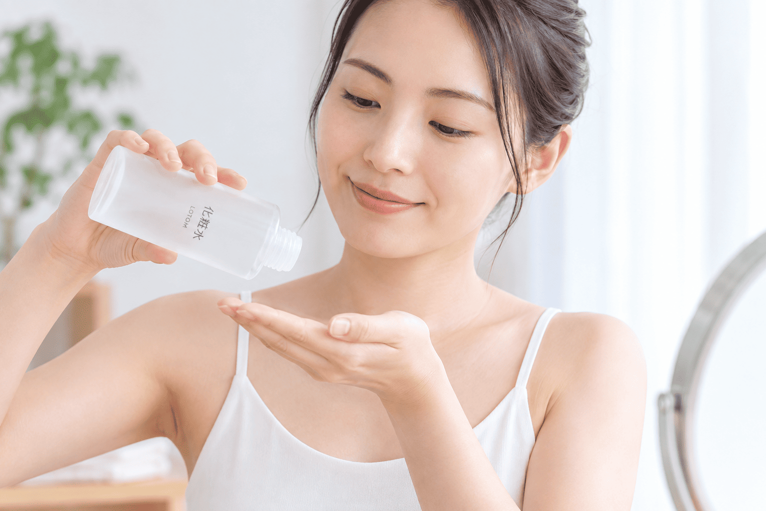 化粧水を手のひらに出す女性